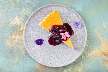 cheesecake with berry jam decorated with edible flowers