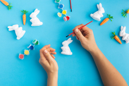 easter white rabbits ready to paint carrots concept handsの写真素材