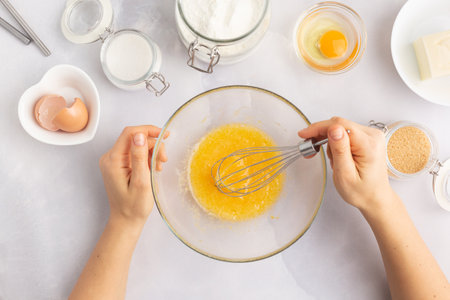 Various baking ingredients - flour, eggs, sugar, butter and kitchen utensils on grey background....
