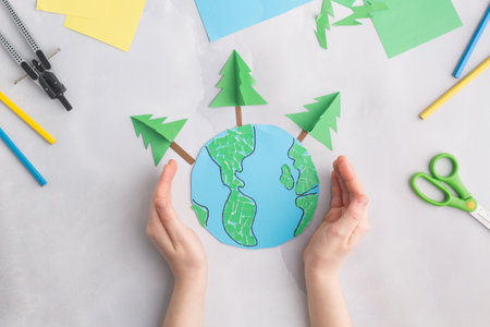 earth cut from paper around trees earth day concept kids paper craftの写真素材