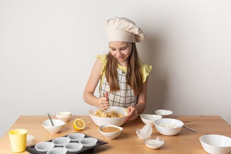 Girl is cooking muffins in the kitchen process concept ingredients simple