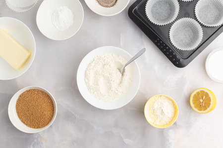 Various baking ingredients - flour, sugar, butter and kitchen utensils on grey background. Top view.の写真素材