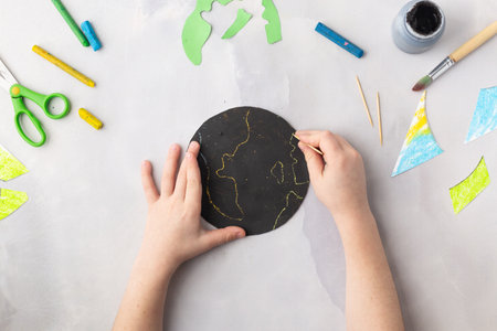 Globe in the night cut from paper and decorated with wax crayons, black paint and toothpick earth day concept kid's paper craft. High quality photoの写真素材