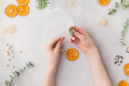 Christmas toy made from dried orange slices, wooden beads and eucalyptus leaves festive holiday interior. High quality photoの写真素材