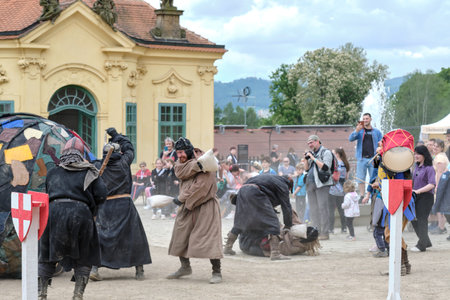 Decin (Tetschen), Czechia - May 14 2023: Medieval show on town market cultural festival on old castle with fighting monks playing soccer with a huge ball among amused spectatorsのeditorial素材