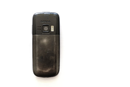 Prague, Czech Republic - September 4 2023: Old well-used dumb cellphone Nokia 6303ci with a 3.2 megapixel camera, flash diode, metal battery cover. Low-tech vintage mobile concept.のeditorial素材