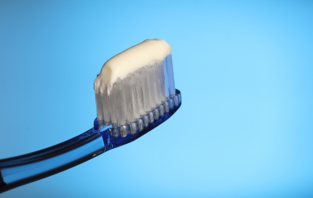 toothbrush with toothpaste on a blue background