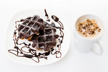 a breakfast two chocolate black waffles and coffee cup isolated in white backgroundの写真素材