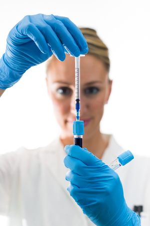 doctor scientist injecting blue reactive into tube
