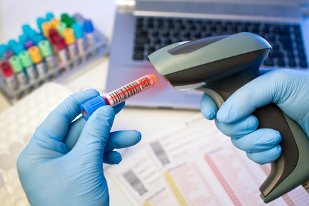 technician hands scanning barcodes on biological sample tube in the lab of blood bank