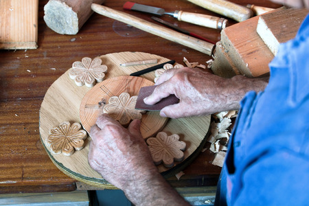 portrait of a hands carpenter planing on composition of wood at work in the workshop / cabinetmakerの写真素材