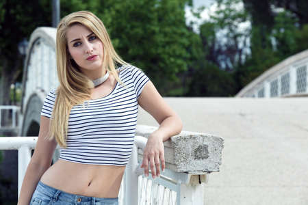 half-length portrait of a woman with worried face next to the bridge  pensive woman near the bridgeの写真素材