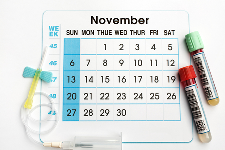 November 2016 planning calendar and blood samples in tubes / blood tubes and needle on the bottom of an appointment calendar of November 2016の写真素材