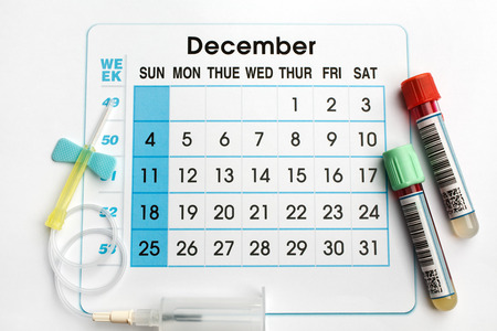 December 2016 planning calendar and blood samples in tubes / blood tubes and needle on the bottom of an appointment calendar of December 2016の写真素材