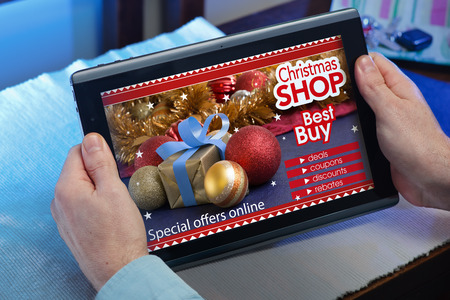 man searching website internet store to purchase Christmas presents online in christmas with your tablet in you home  hands of a man at a website with an announcement concept purchase Christmas presents onlineの写真素材