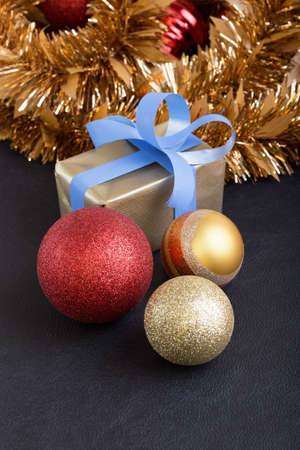 present and christmas balls in gold, red as background vertical for copyspace  present and christmas balls in black backgroundの写真素材