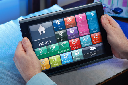 businessman in the office holding a tablet and looking screen interface application man working with the software of tablet pc at homeの写真素材
