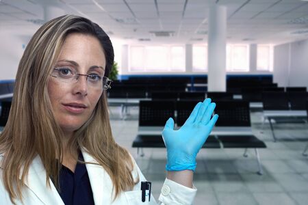 Portrait of female doctor inviting to enter to the waiting room of the clinic / doctor woman...