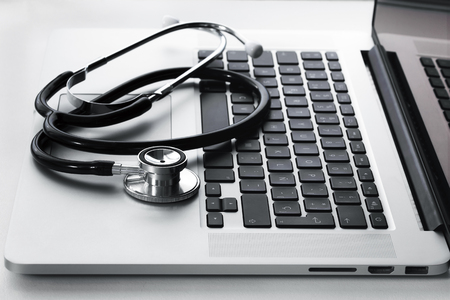 medical stethoscope on laptop keyboard / stethoscope on the keyboard of computerの写真素材