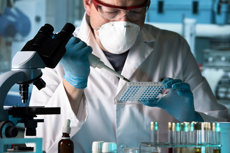 scientist working with microplate in a pharmaceutical lab / biomedical engineer working with samples in microplate in the laboratoryの写真素材