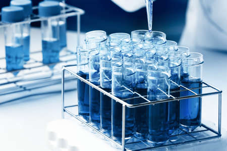Researcher working with tubes in chemistry lab. Scientist pipetting samples into test tubes in the...