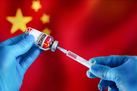 Doctor preparing vial of vaccine injection for the vaccination plan against diseases in China. Preparing dose of vaccine in syringe for infections prevention in front of the China flagの写真素材