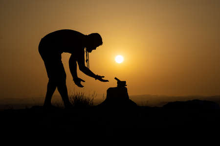 silhouette of person meditating at sunsetの写真素材