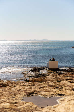 Rear view of a mother and daughter standing on the beach. High quality photoの写真素材