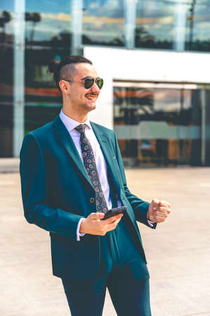 Middle age man wearing business suit very happy and excited doing winner gesture with arms raised, smiling and screaming for success. celebration concept.の写真素材