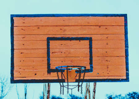 Old worn wooden basketball shield with basket.