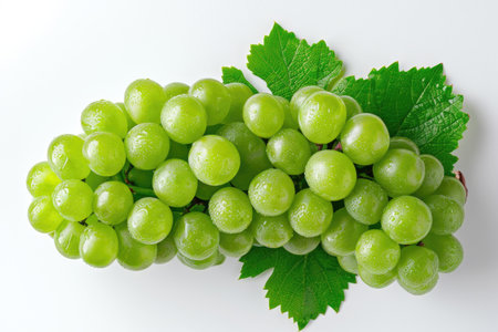Bunch of Green Grapes With Leaves on a White Background A cluster of green grapes, complete with leaves, arranged neatly on a white background.の素材