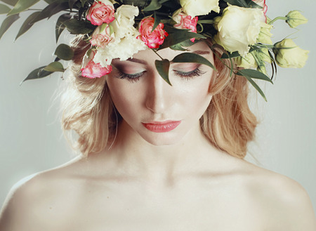 girl with a wreath of flowers on her head on white backgroundの写真素材