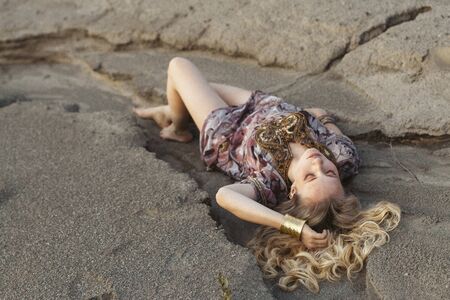 blonde sandy cliffs in a beautiful dressの写真素材