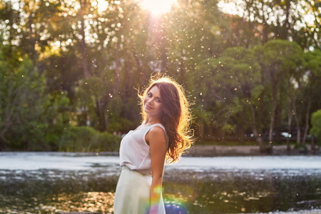 Beautiful girl in elegant dress and charming smile posing for the photographer in the park of Yekaterinburgの写真素材
