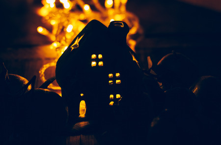 Beautiful Christmas decoration with tangerines and a toy house in the night light garlands. Citrus still life. The symbol of the new yearの写真素材