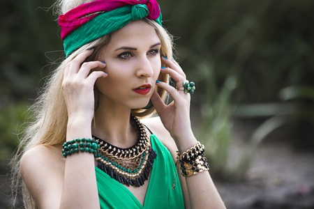 Attractive beautiful blonde girl in shorts and a headband walks and posing in the Park in the nature near the water. Perfect makeup and beautiful Oriental lookの写真素材