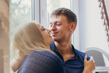 Loving couple sitting on the window, loving and gentle look. Positive emotion, smiling faces. Couple...