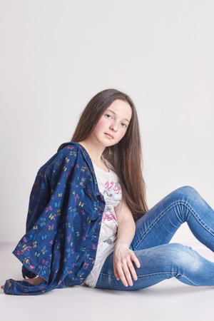 Russia Ekaterinburg - April 1, 2016: Fashion fun girl in jeans posing on a white background. Model school for children. Beautiful girl smiling. Summer timeのeditorial素材