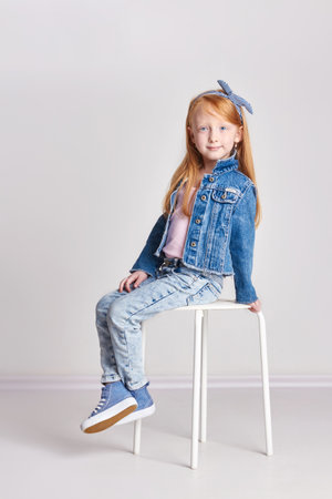 Russia Ekaterinburg - April 1, 2017: Little girl with red hair, beautiful long hair. Redhead child posing on a light background, fashion model school. Joy and funのeditorial素材
