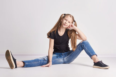 Russia Ekaterinburg - April 1, 2017: Cheerful girl with long pigtails posing on light background. Bright positive emotions, a smile on her face. Teen girlのeditorial素材