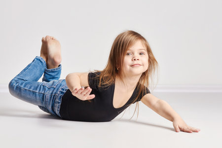 Russia Ekaterinburg - April 1, 2017: Little girl child with red hair, beautiful long hair. Joy and fun. Posing on a light background, fashion model schoolのeditorial素材
