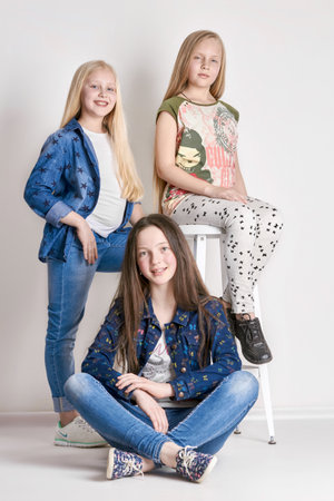 Russia Ekaterinburg - April 1, 2016: Three girls posing, a model school for children. Fashion art fashion. Sisters together on a light background. Bright summer clothesのeditorial素材