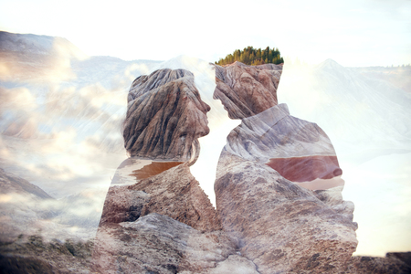 Double exposure man and woman couple hugging with mountains in background. Mountains inside couple in love. Lovers look at each other, tender feelings and love, superimposition of two framesの写真素材