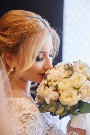 Perfect wedding day of woman bride, portrait of girl in white wedding dress in Bridal veil. Morning of the bride waiting for the groom and wedding ceremonyの写真素材