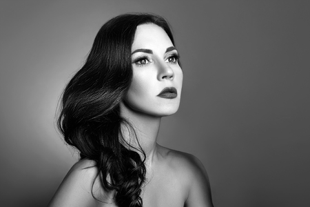 Black and white portrait of a woman with perfect clean skin close-up. Beautiful brunette on dark backgroundの写真素材