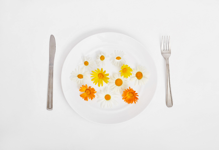 Woman and beautiful spring flowers in plate, hands and skin care, natural cosmetic, summer flower extract. Anti-aging cosmetics for hands and body, body care cream. Professional moisturizing cosmeticsの写真素材