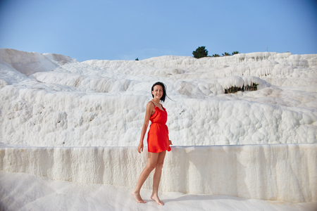 Girl in red dress on white travertines, Pamukkaleの写真素材