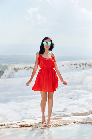 Girl in red dress on white travertines, Pamukkaleの写真素材