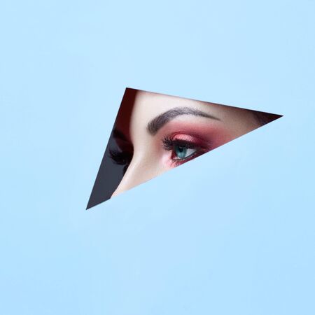 Woman in a round hole circle in purple background, Beauty makeup cosmetics nature fashion, copy space advertising. Professional makeup perfect skin and shiny lipstick. Advertising banner, book coverの写真素材