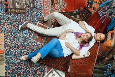 Couple in love walks and hugs at the Eastern carpet market. A man and a woman choose a Turkish carpetの写真素材